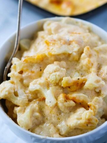 baked cauliflower mac and cheese in a bowl with a spoon