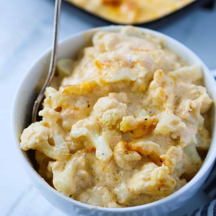 baked cauliflower mac and cheese in a bowl with a spoon