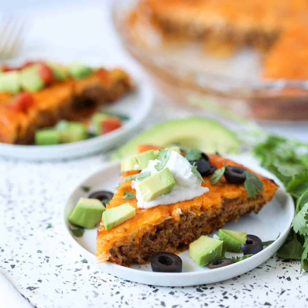 crustless taco pie with garnishes on a white plate