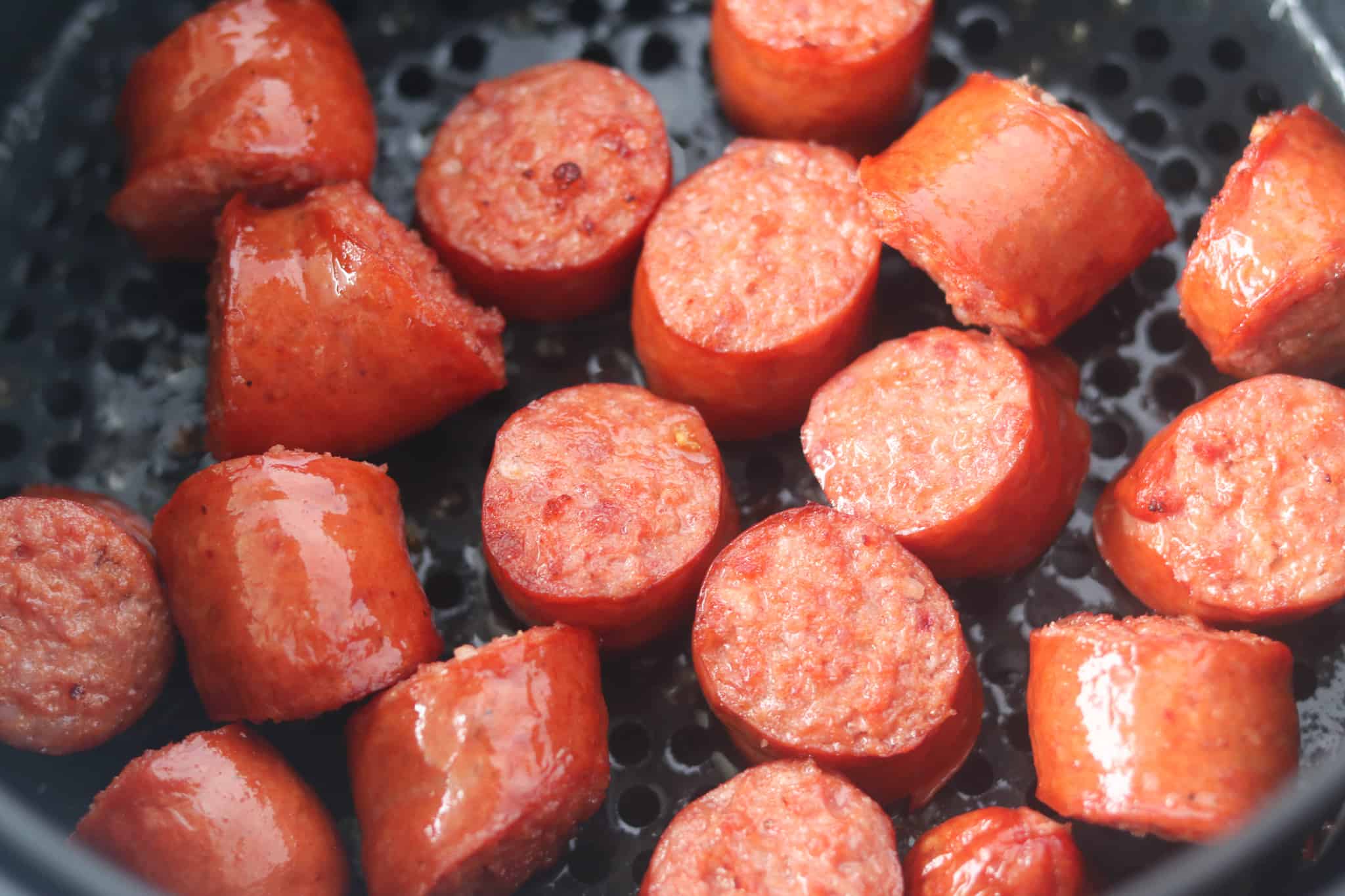 cooked polish sausage in air fryer cooked at a side angle