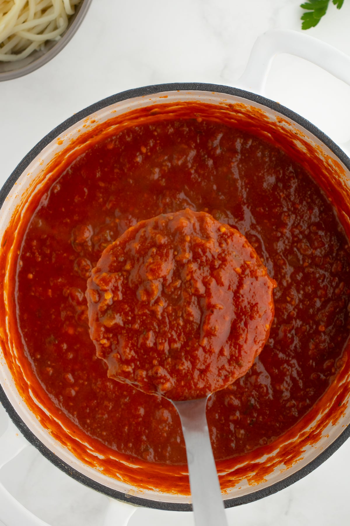easy keto spaghetti sauce with meat in a dutch oven on a ladel