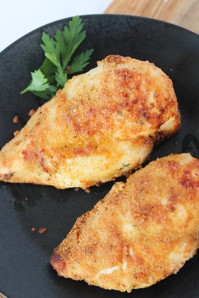 air fryer chicken breast breaded on a black plate after cooking