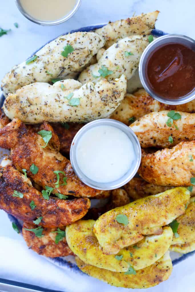 air fryer chicken tenderloins no breading on a plate with 4 different seasoning options