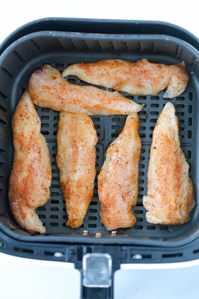 air fryer chicken tenderloins without breading naked with rub in an air fryer before cooking in an air fryer basket