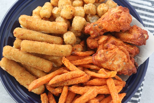 air fryer sweet potato fries frozen on a plate with other types of air fryer snacks