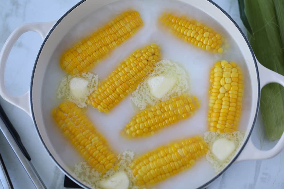 boiling corn with milk and butter in a pot