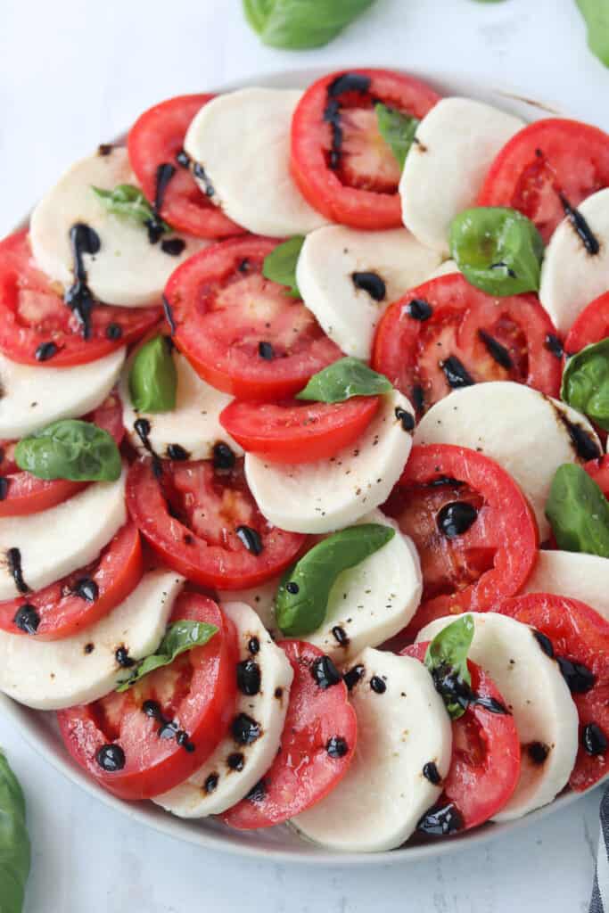 caprese salad with balsamic glaze on a platter ready to serve