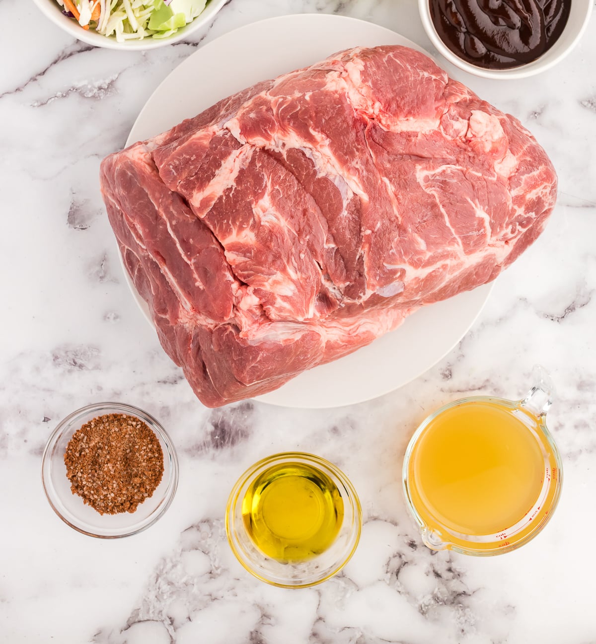 pulled pork roast ingredients on a white marble cutting board