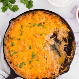 chicken enchilada casserole keto after cooking in a skillet with some of the casserole out of the pan