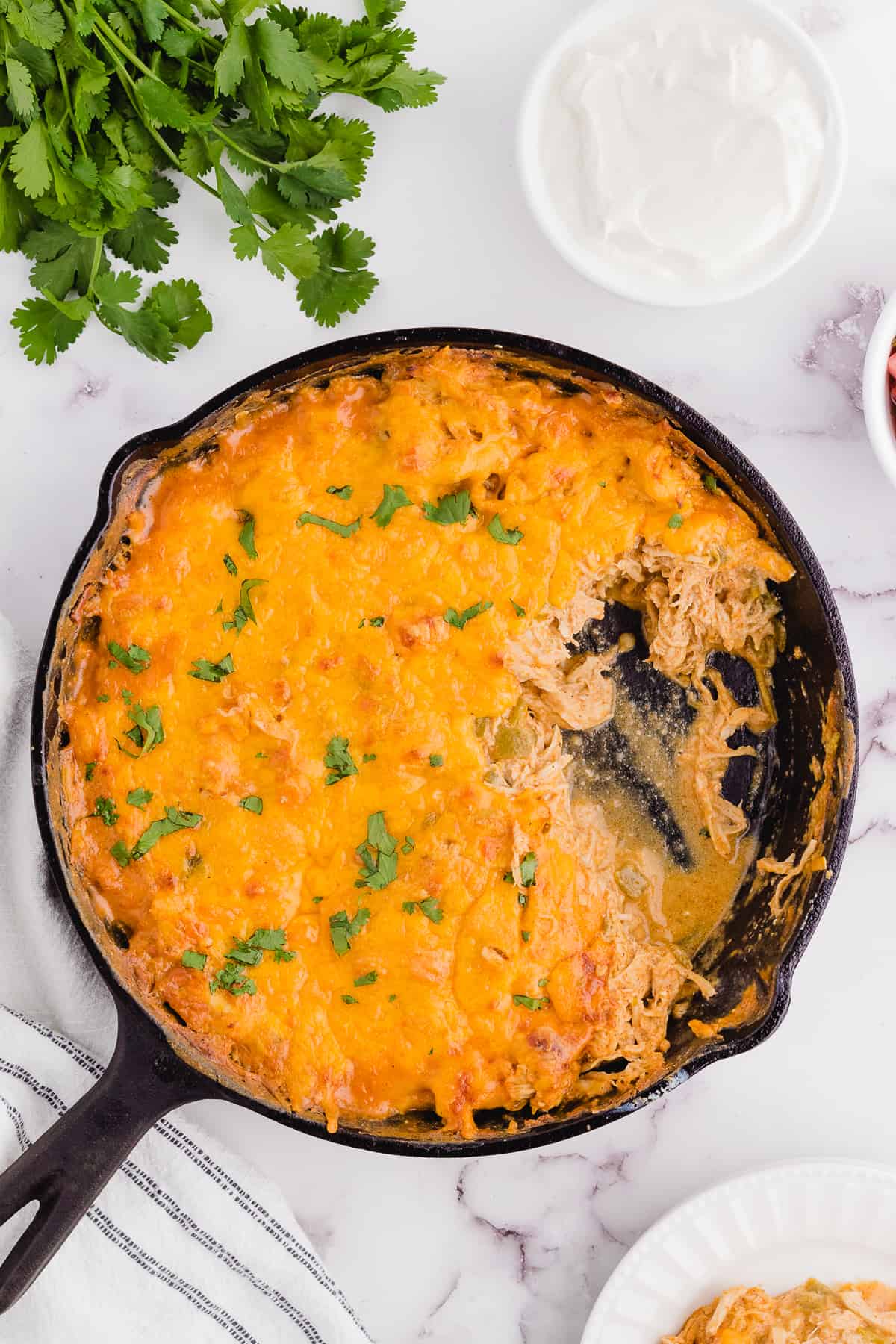 chicken enchilada casserole keto after cooking in a skillet with some of the casserole out of the pan
