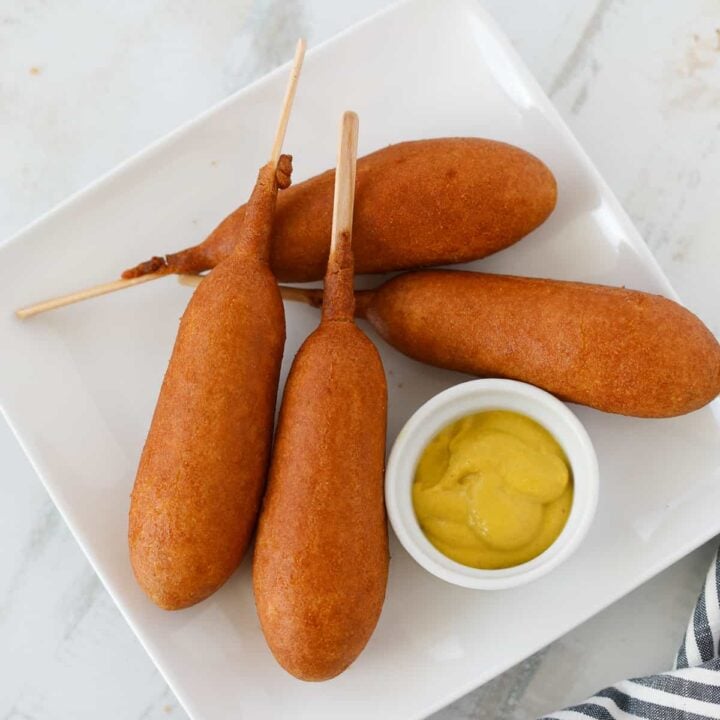 air fryer frozen corn dogs on a plate with mustard