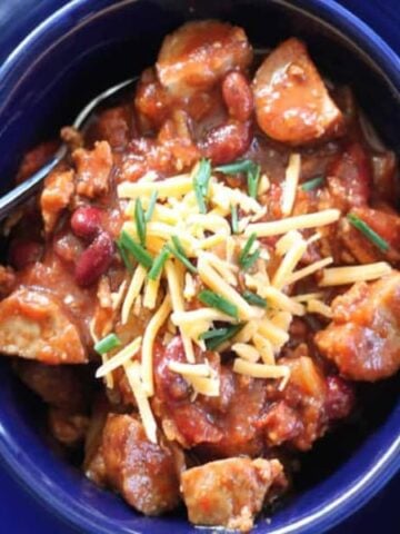 kielbasa chili in a blue bowl square image looking down