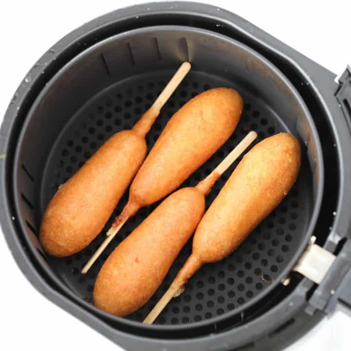 frozen corn dogs in air fryer basket ready to be cooked