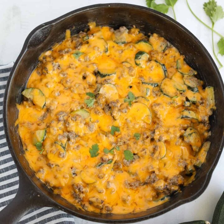 ground beef zucchini casserole in a skillet on a white background after cooking
