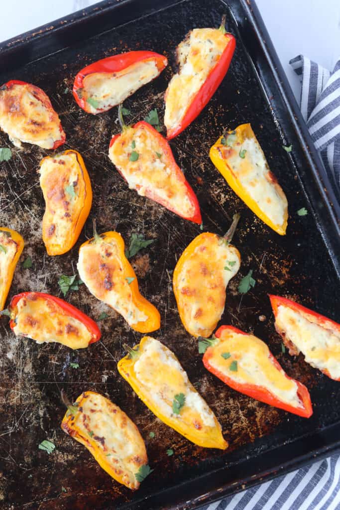 stuffed mini peppers with a view of the entire baking sheet after cooking