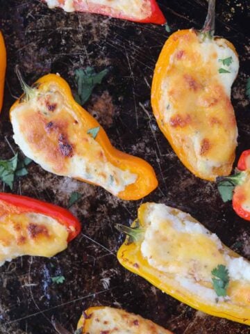keto appetizers like stuffed mini sweet peppers on a baking sheet after cooking with melted cheese