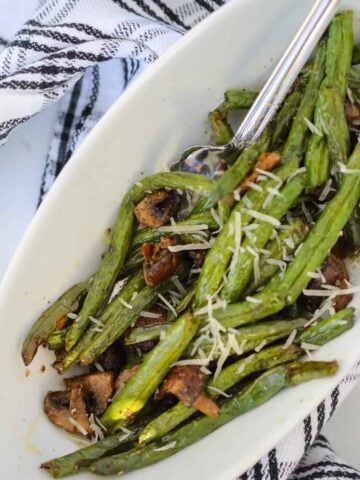 air fryer green bean with mushroom recipe in a white bowl sprinkled with parmesan