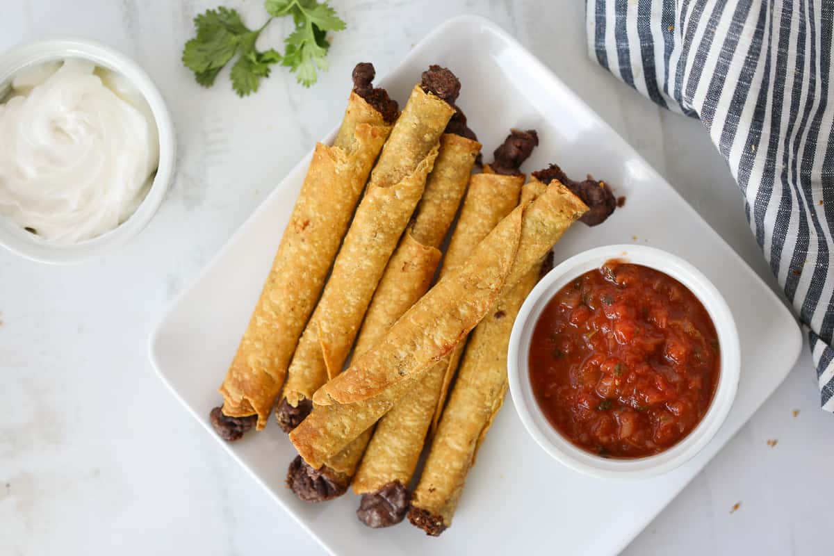 cooking air fryer taquitos frozen is an easy snack or dinner served with salsa and sour cream.