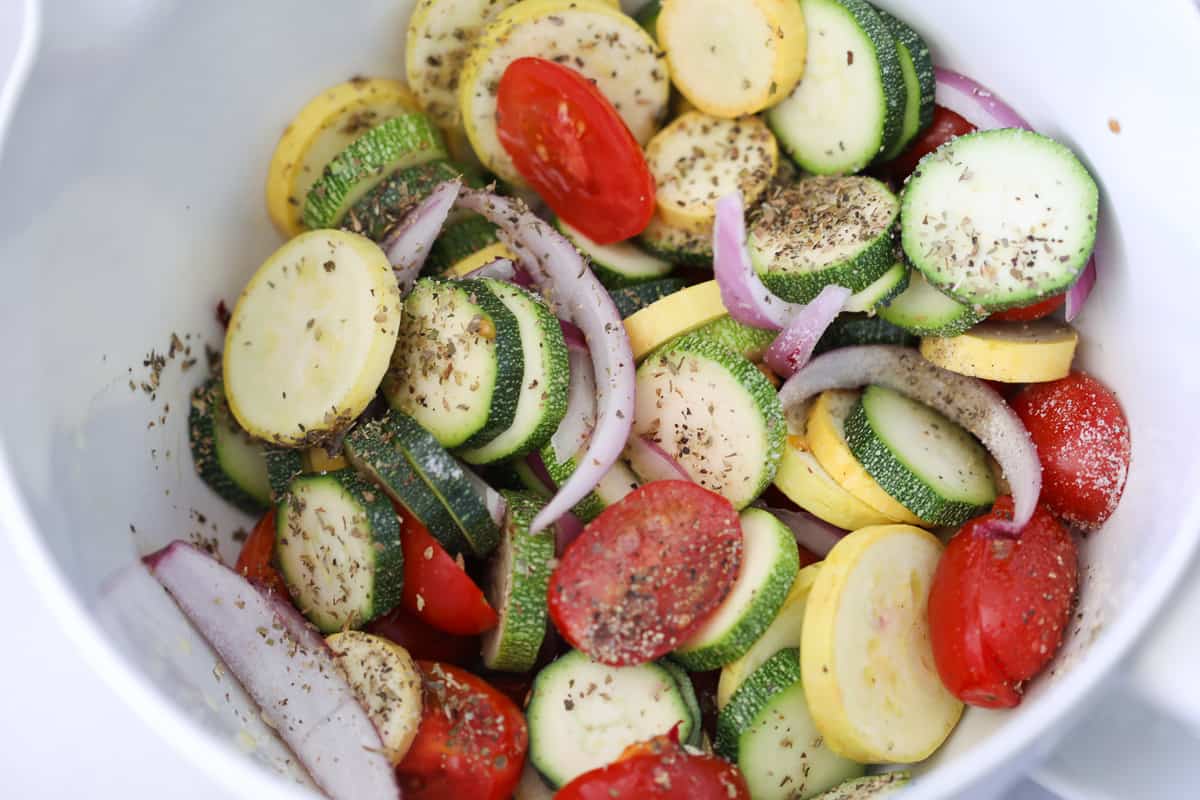 crispy baked zucchini and squash ingredients in a bowl getting mixed