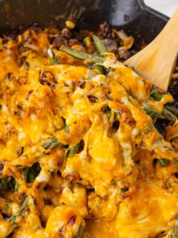 close up of the green bean beef casserole on a wooden spoon