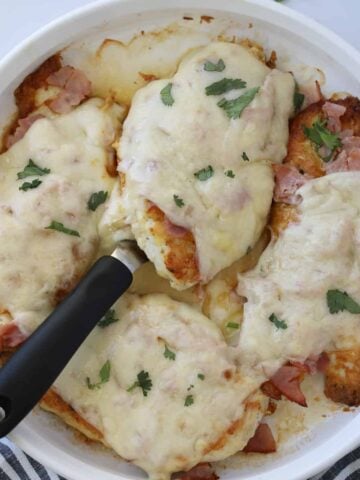 keto chicken cordon bleu after cooking in a round white serving dish