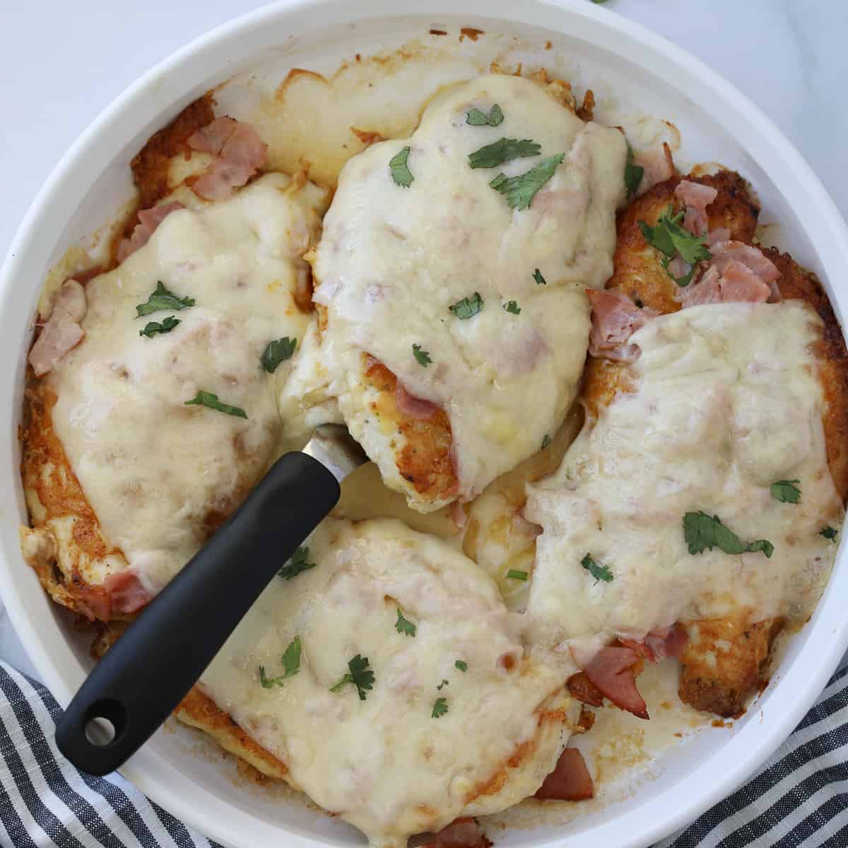 keto chicken cordon bleu after cooking in a round white serving dish