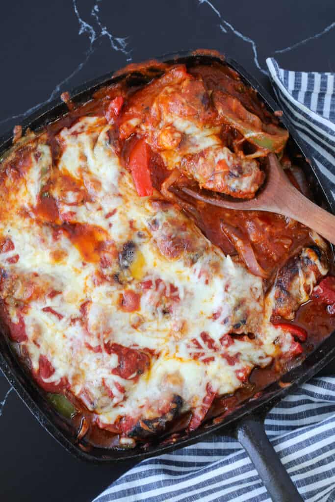 italian sausage bake in a cast iron skillet on a black blackground