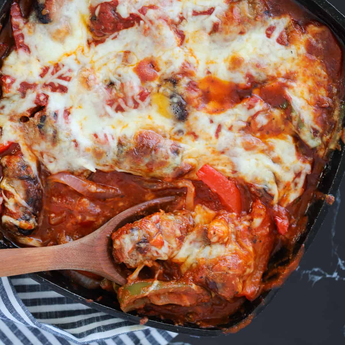 baked italian sausage with a spoonful of casserole