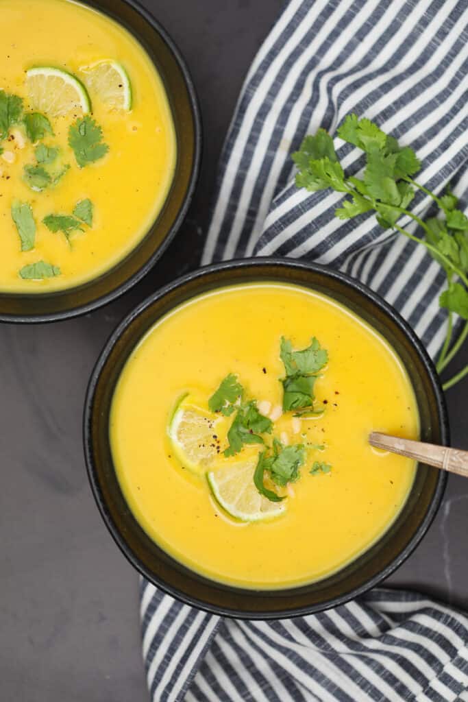 butternut squash soup paleo recipe in a black bowl on a black background