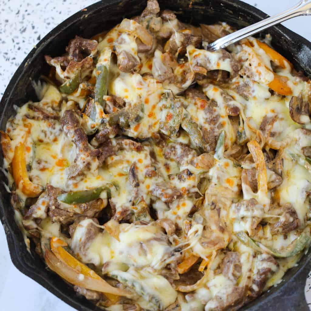 philly cheese steak casserole square with a spoon in the pan
