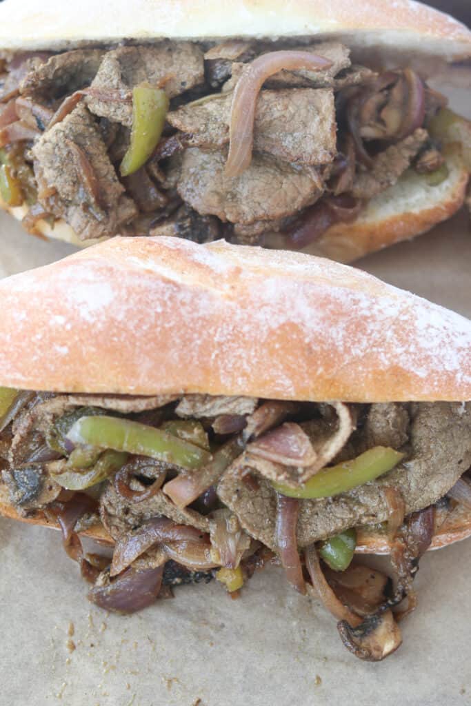 the Philly steak and cheese recipe getting stuffed into hoagie rolls
