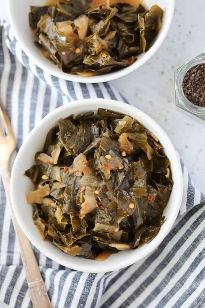 vegan collard greens in a white bowl with a striped cloth