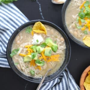 black bowls on a black background of white chicken chili instant pot dishes