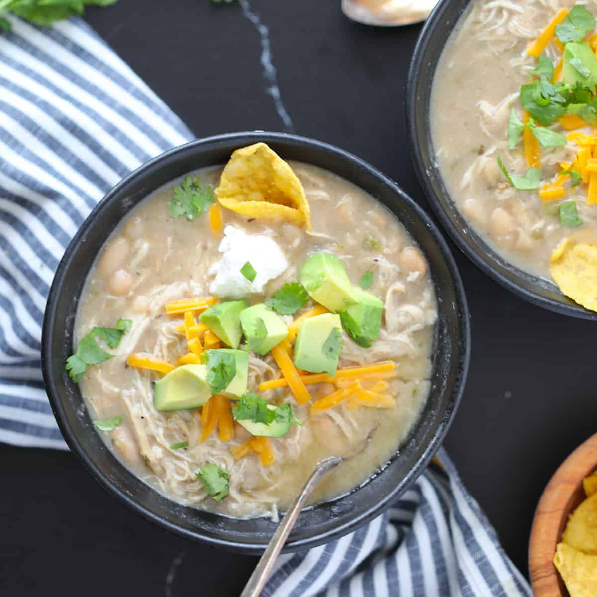 black bowls on a black background of white chicken chili instant pot dishes