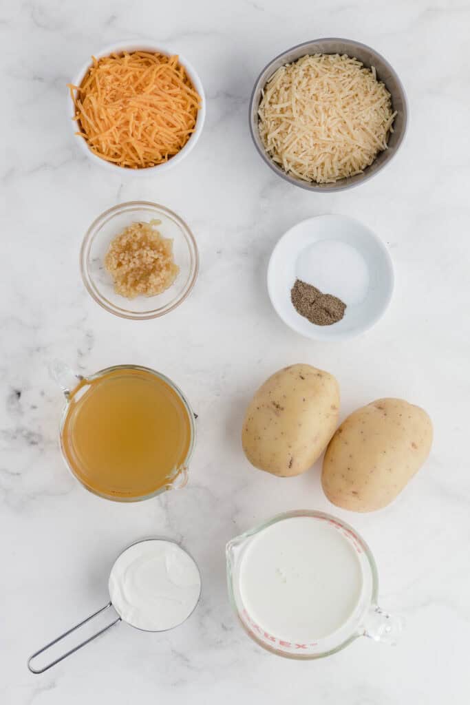 scalloped potatoes ingredients on a white cutting board 