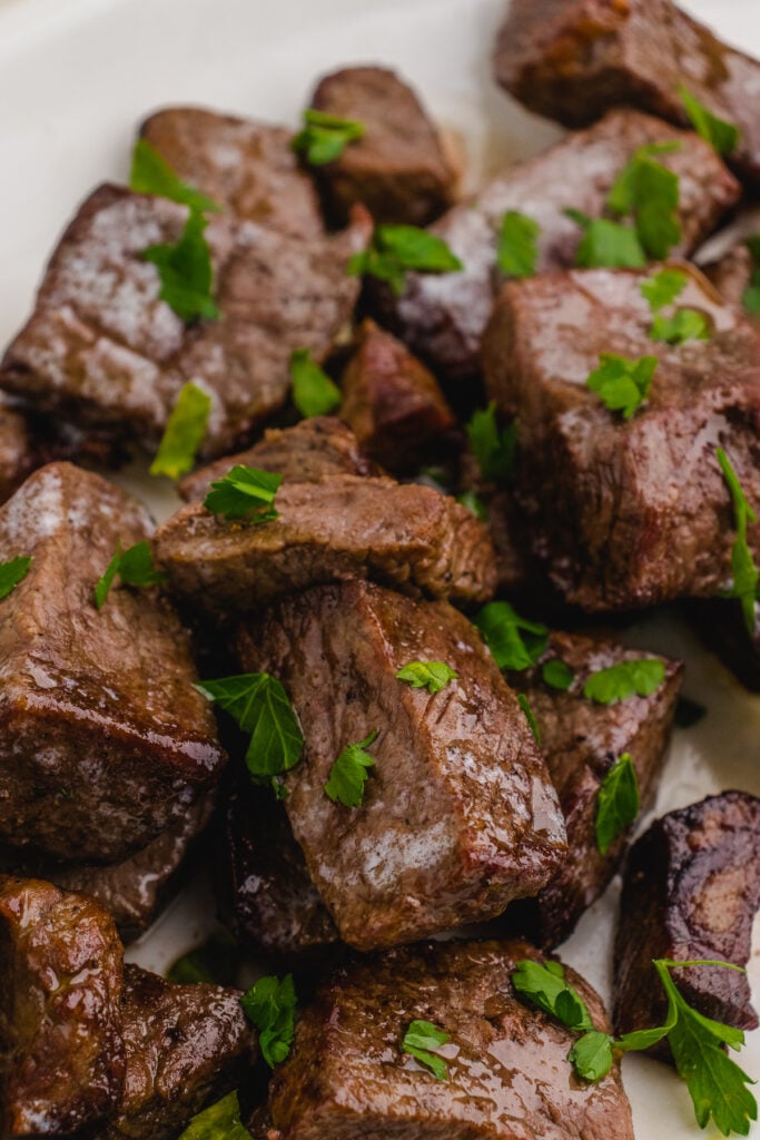steak tip bites in an air fryer close up  on a white plate
