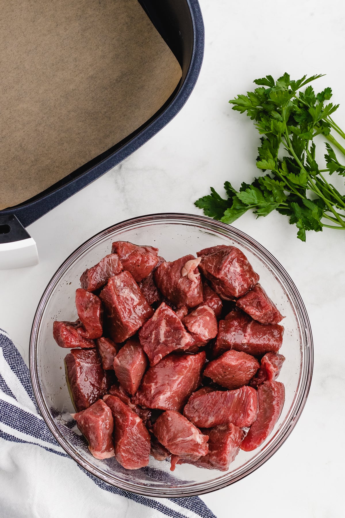 seasoning steak tips in a bowl with garlic salt and pepper