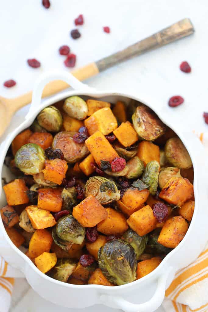 butternut squash and brussel sprouts in a white serving dish