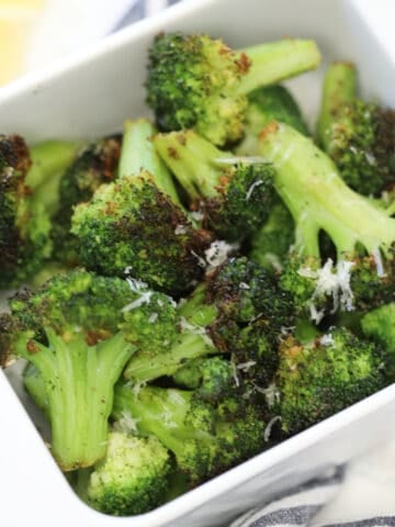 the frozen broccoli air fryer recipe in a white dish on a white background