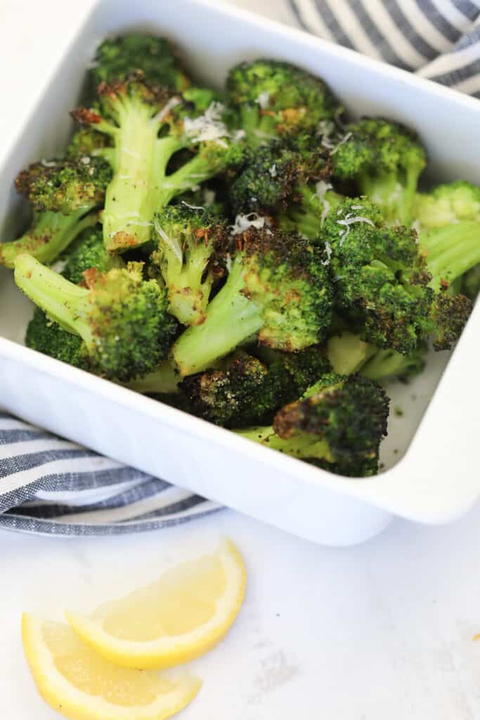 the frozen broccoli in air fryer recipe in a white dish with lemon