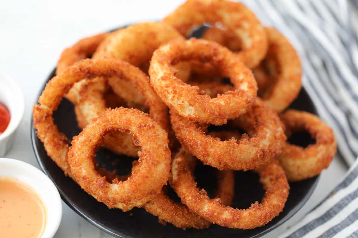 frozen onion rings air fryer recipe stacked up on a plate