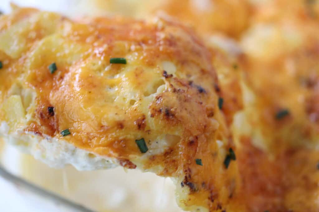 a cheesy bite on a spoon of instant pot scalloped potatoes recipe