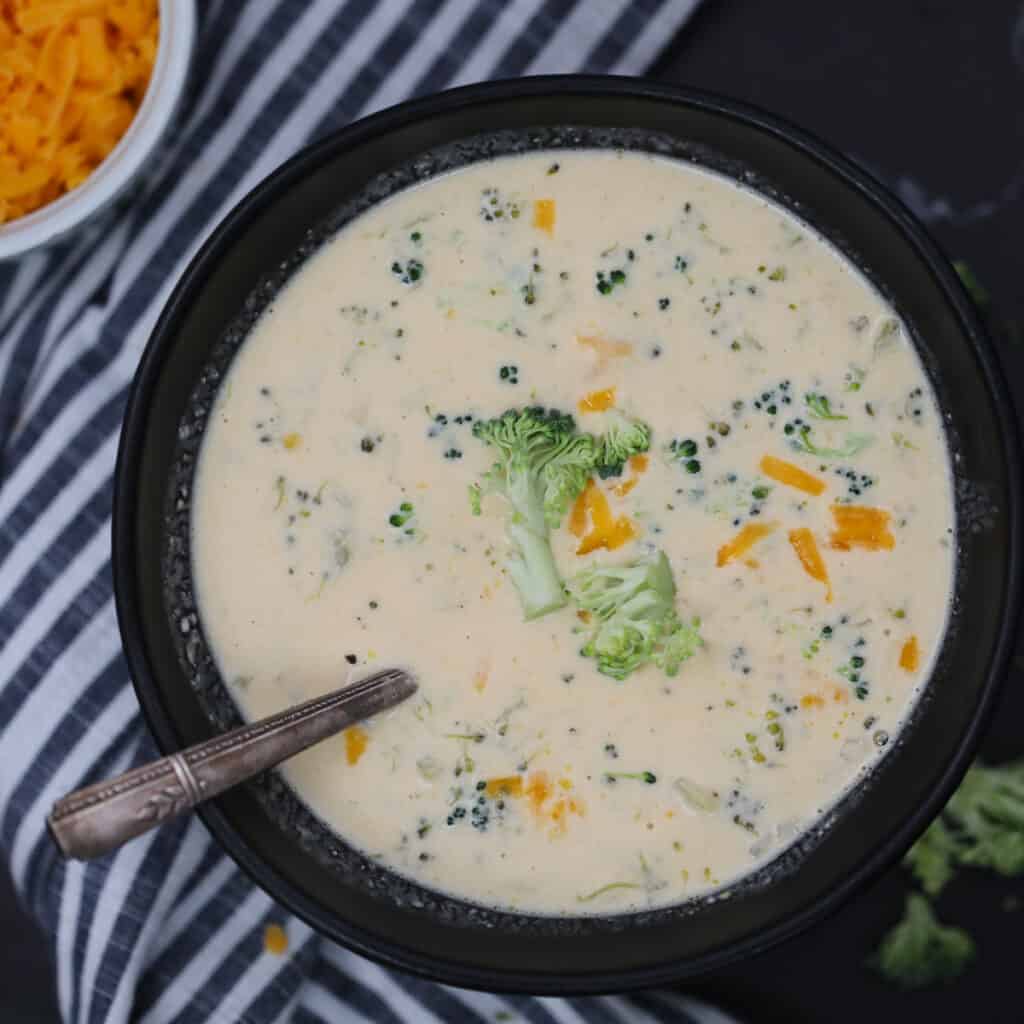keto broccoli and cheese soup in a black bowl with a spoon