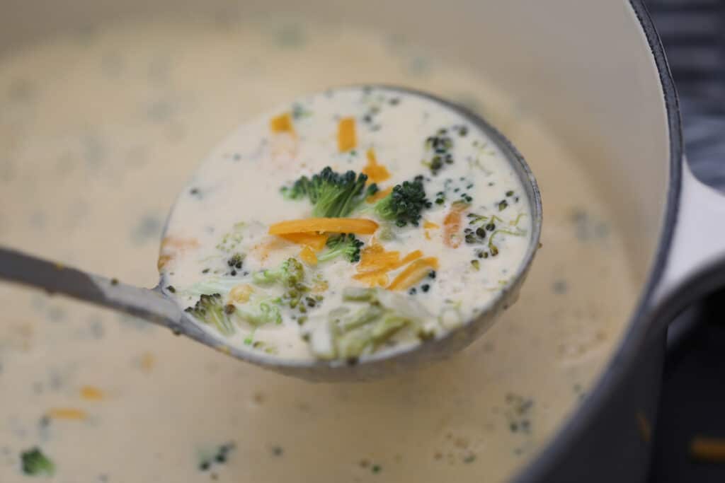 low carb broccoli cheese soup in the pot with a ladle of soup