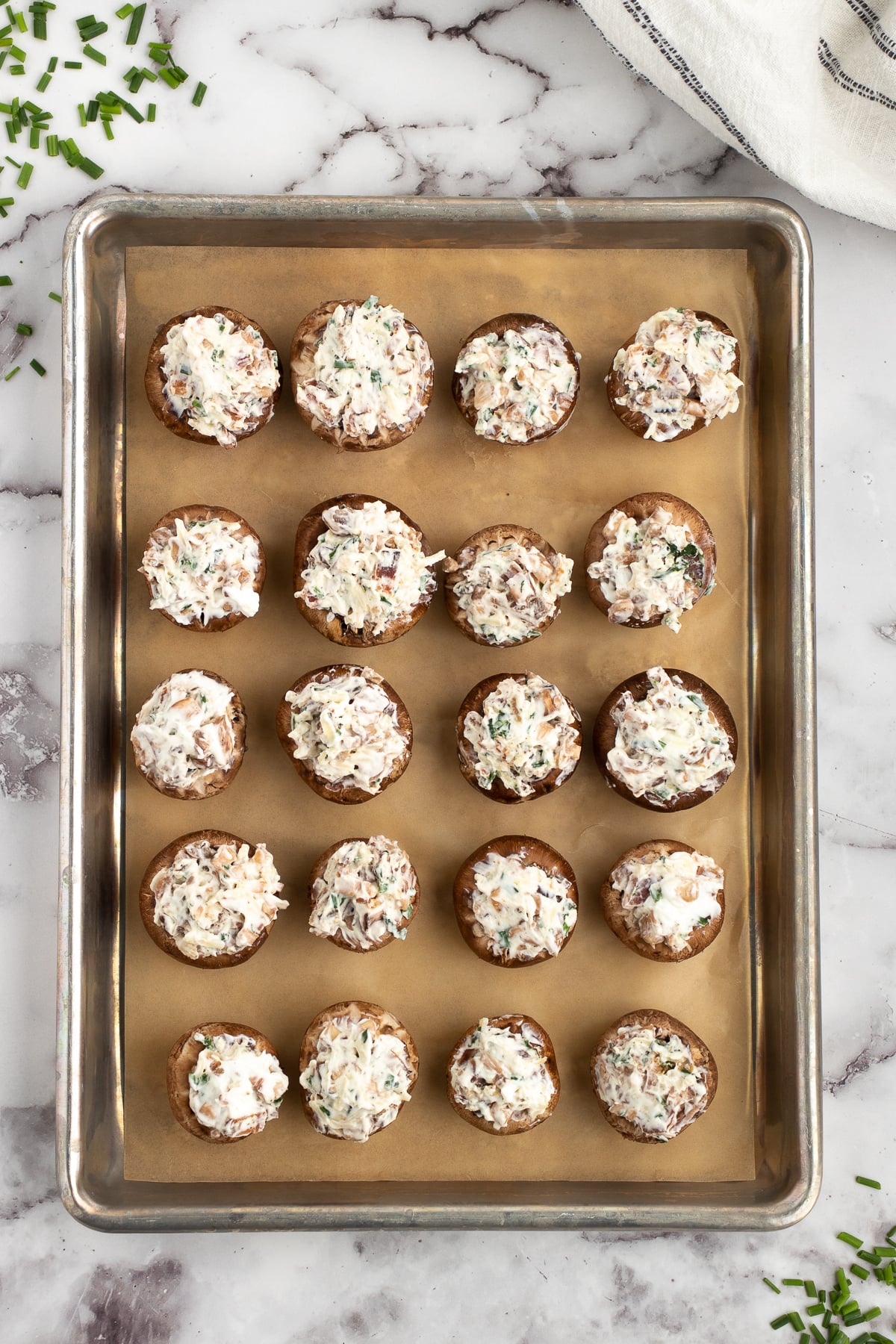 adding the bacon bits cream cheese filling to the mushrooms before baking in the oven