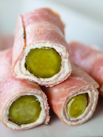 ham pickle roll-ups in logs stacked on a plate