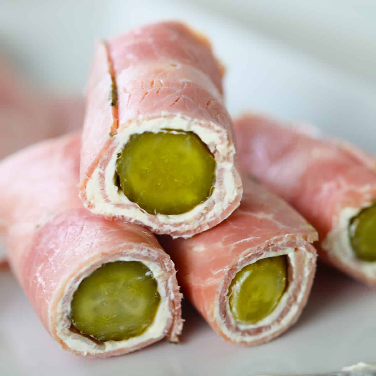 ham pickle roll-ups in logs stacked on a plate