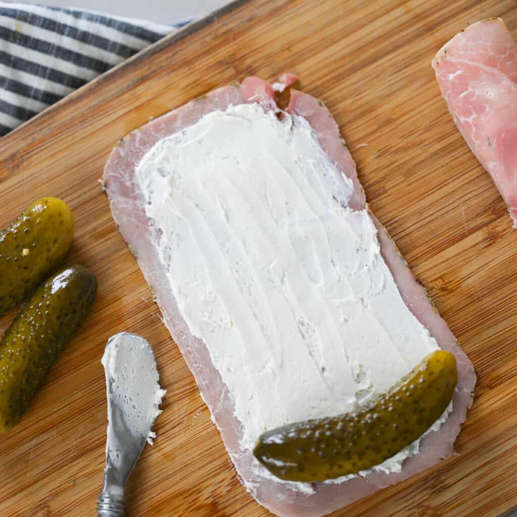 rolling the pickle cream cheese ham snack into logs