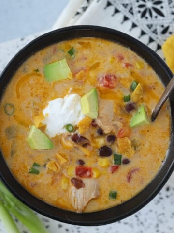 instant pot chicken taco soup with sour cream and cheddar cheese on a white background