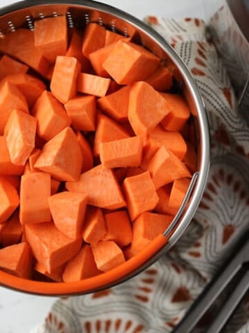 instant pot sweet potatoes cubed in a vegetable basket before cooking